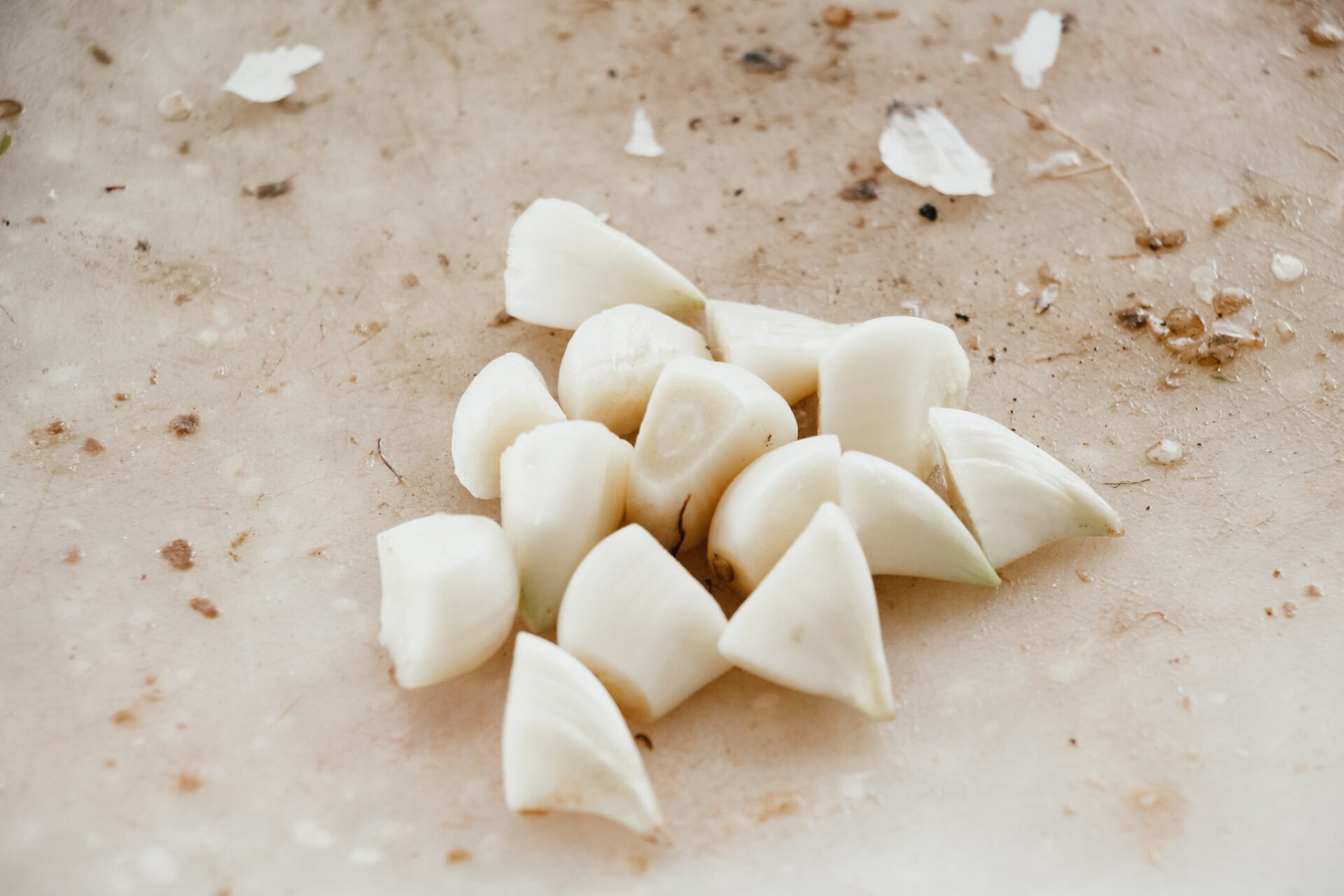 chopped garlic cloves on a white plastic cutting board