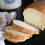 soft sourdough sandwich loaf with slices cut laying in front of loaf.