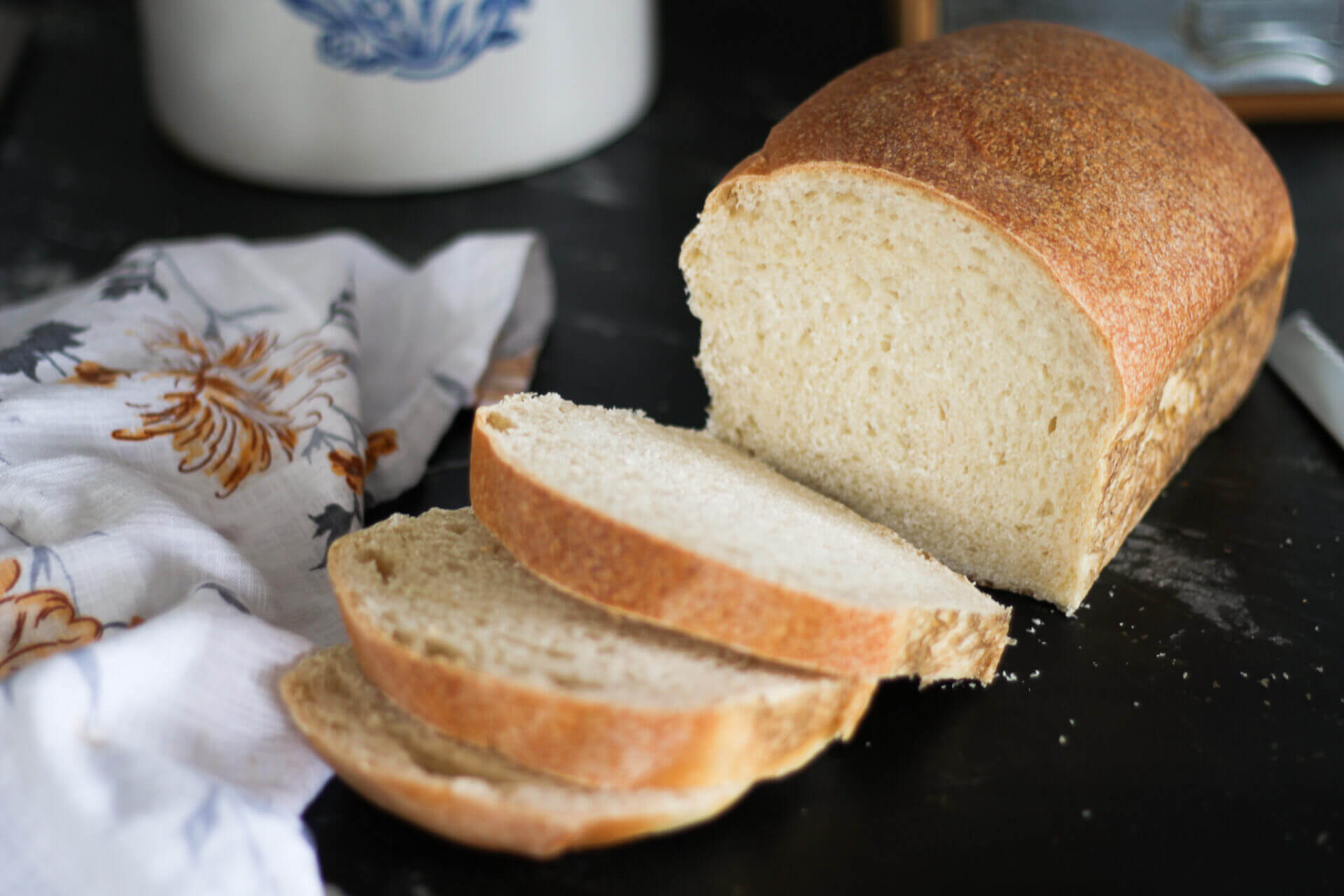 sourdough amish bread sliced on the black counter top into multiple pieces