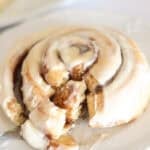 sourdough cinnamon roll with fork taking bite out.