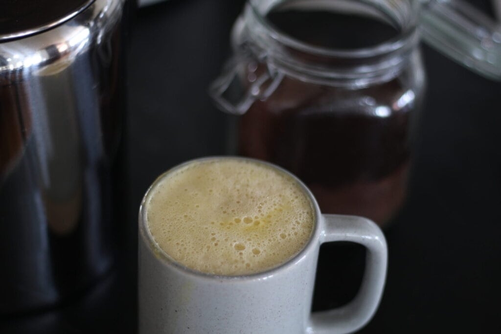 creamy egg yolk coffee in gray mug.