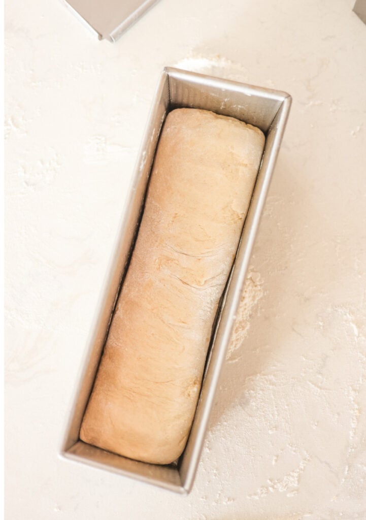 sourdough pullman loaf dough shaped and placed seam side in pan.