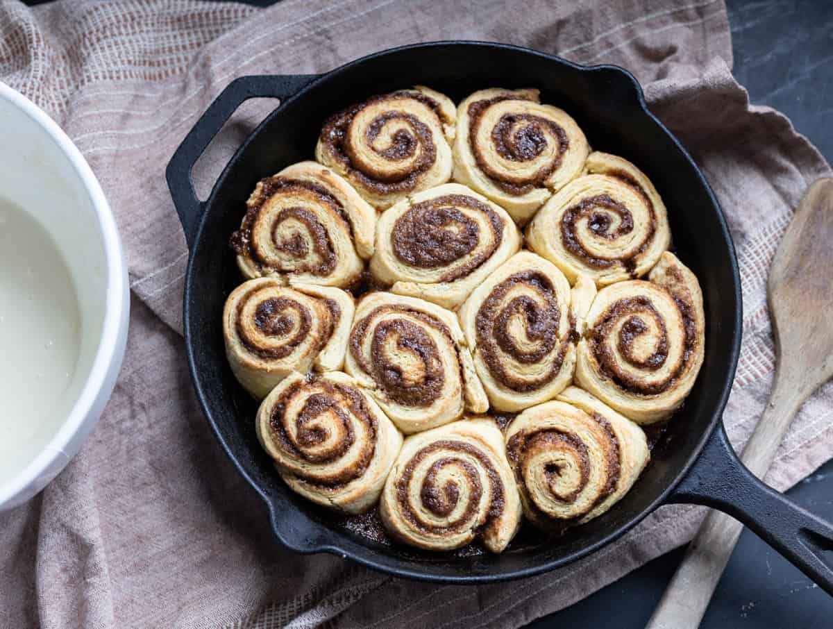 easy sourdough cinnamon rolls baked in cast iron skillet ready for glaze.