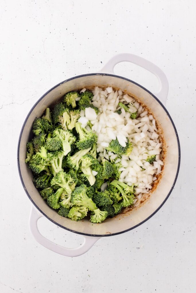 adding broccoli and onion to chicken pasta