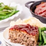 sliced meatloaf on a plate with mash potatoes
