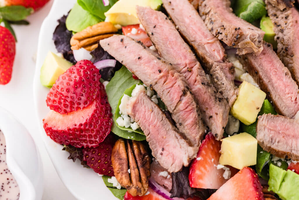 a close up view of the steak on top of the salad