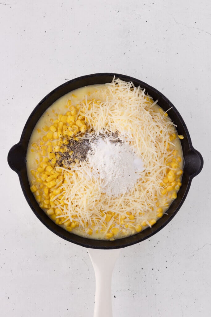 Unmixed creamed corn ingredients in a skillet