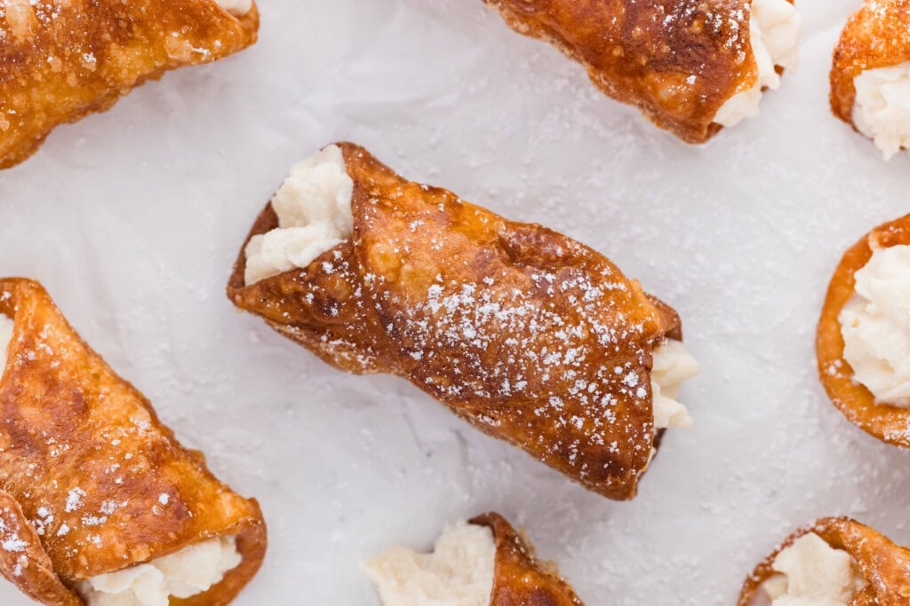 golden brown fried sourdough cannoli with ricotta filling.