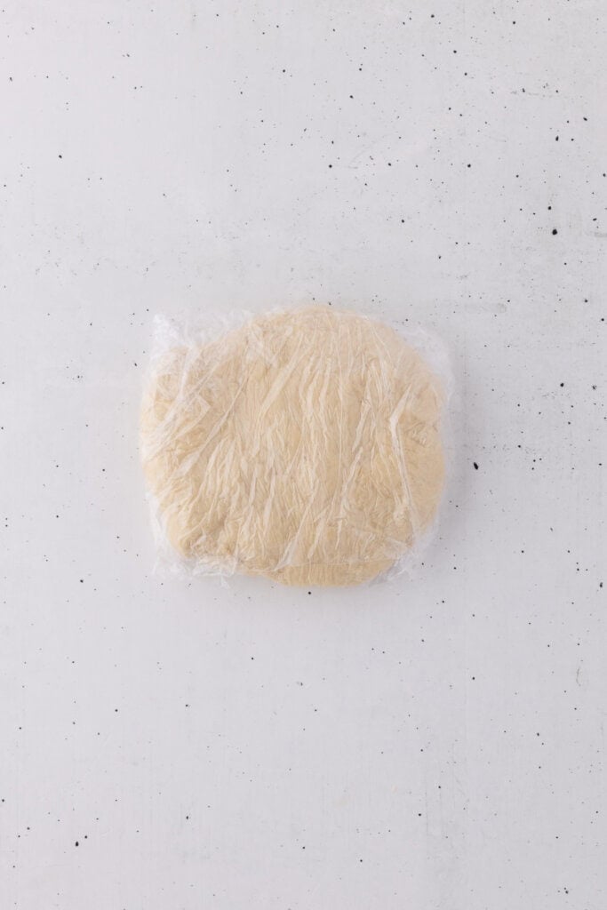 dough shaped into disc and covered with plastic wrap.
