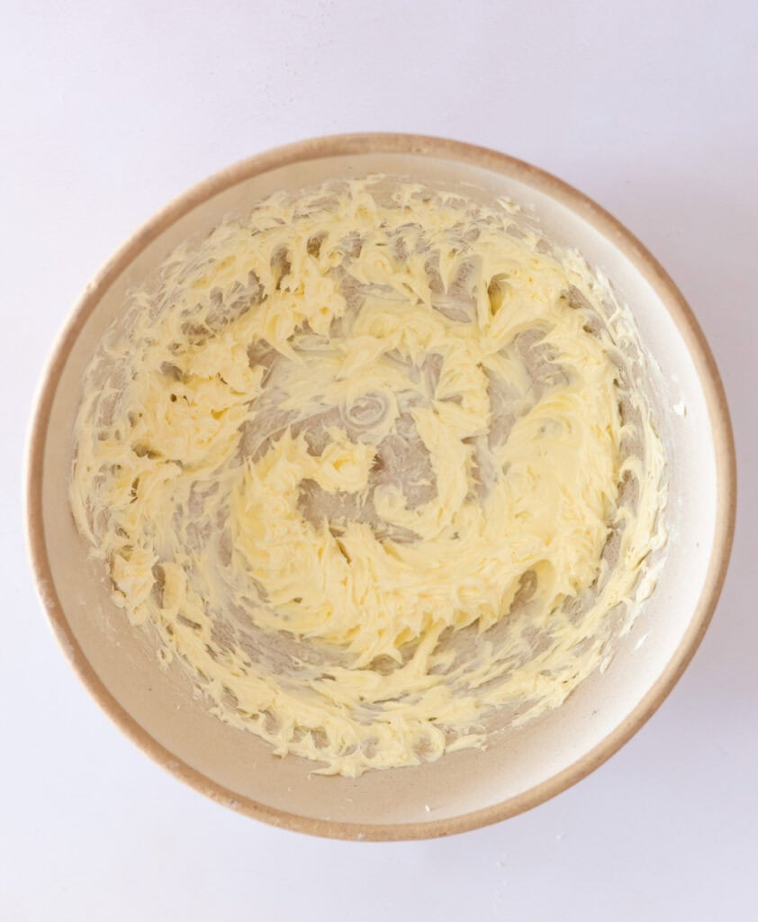 whipped creamy butter in mixing bowl for making chocolate frosting.