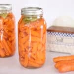 jars of fermented carrots with salt box in background.