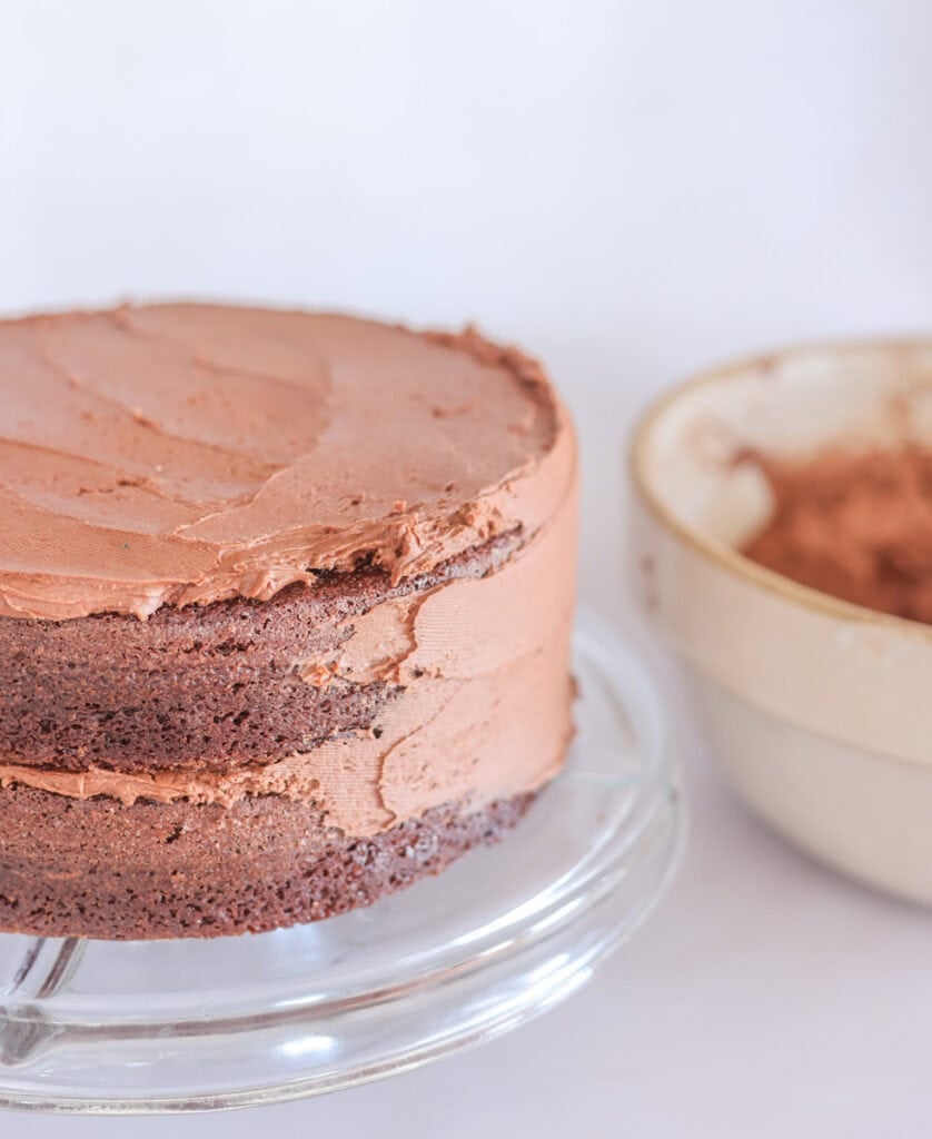 spreading icing on sides of double layer sourdough chocolate cake.