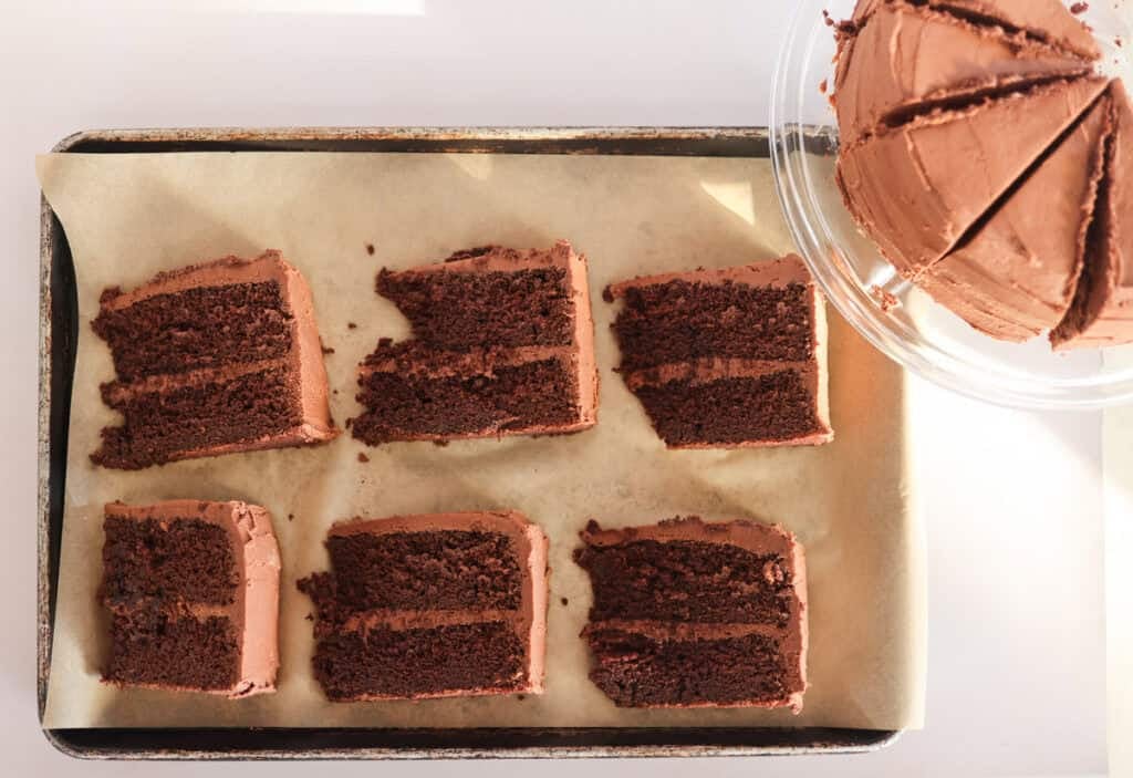 6 slices of sourdough chocolate cake on lined baking sheet for freezing.
