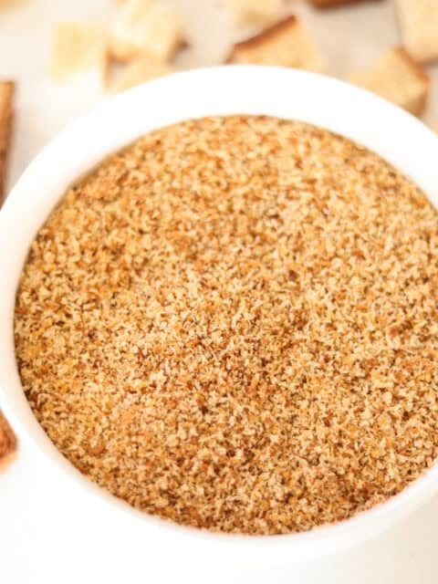 bowl of sourdough breadcrumbs with slices of bread to side.