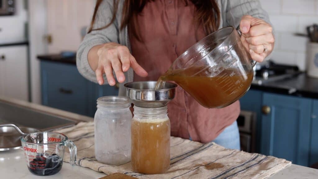 filling hot quart jars with hot bone broth.