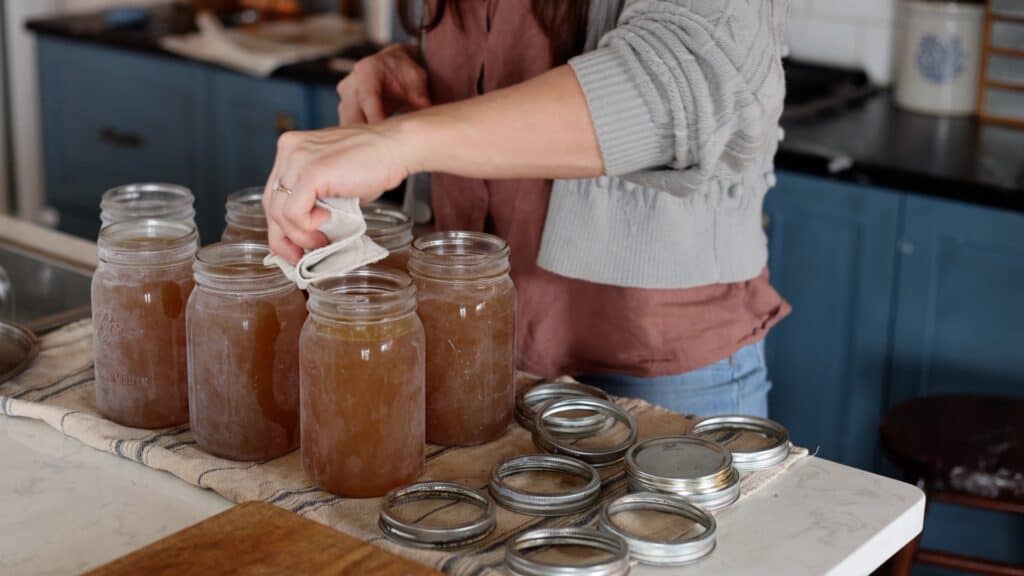 cleaning rims of jars with a cloth before canning.