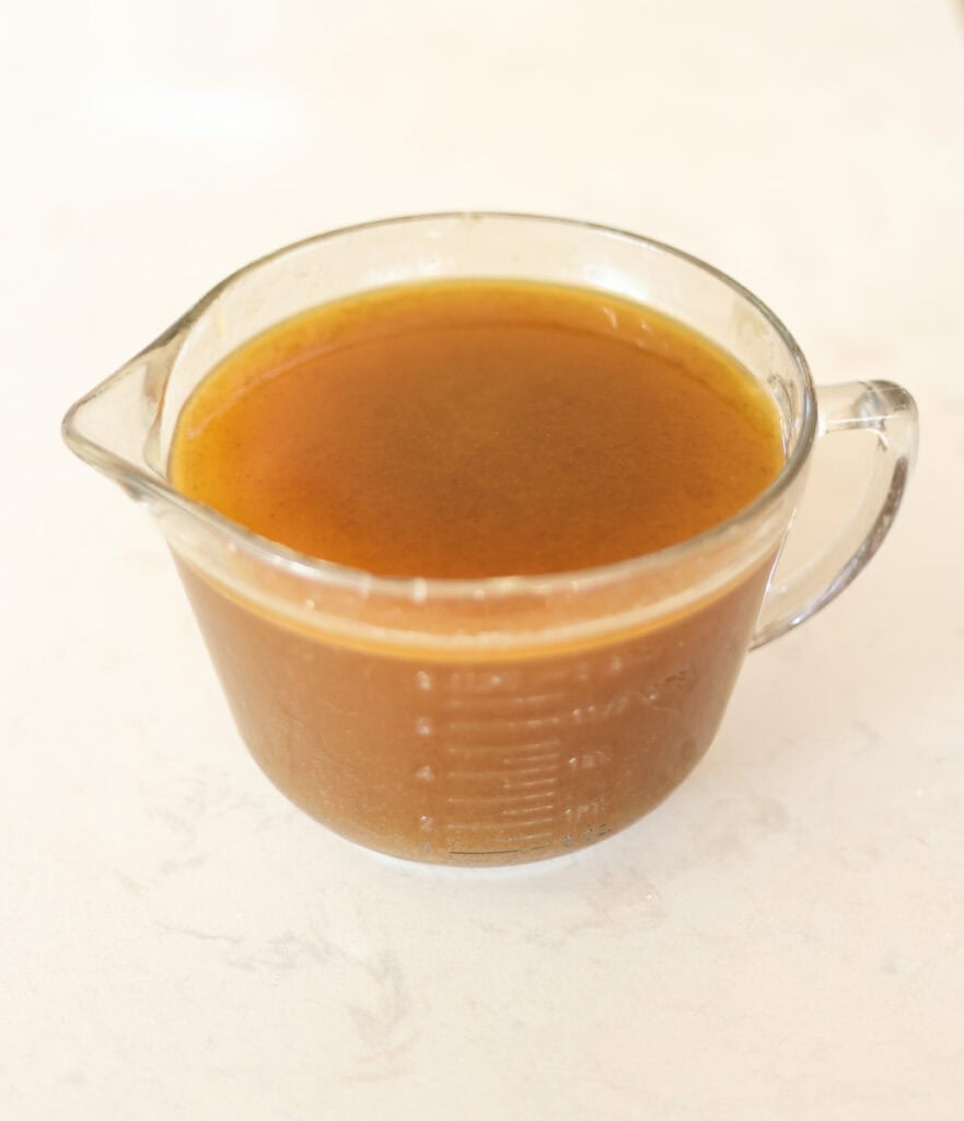 chilled and defatted chicken bone broth for canning.