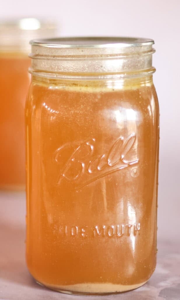 quart jar of bone broth with ring removed.
