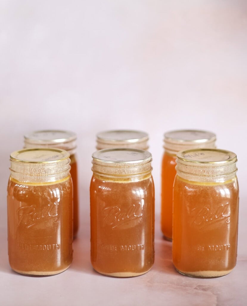 pressure canned jars of bone broth with rings removed ready for storage.