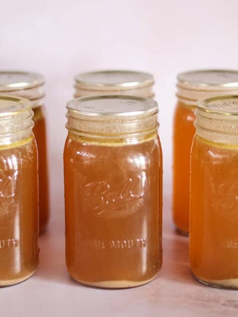 six jars of pressure canned bone broth with rings removed.