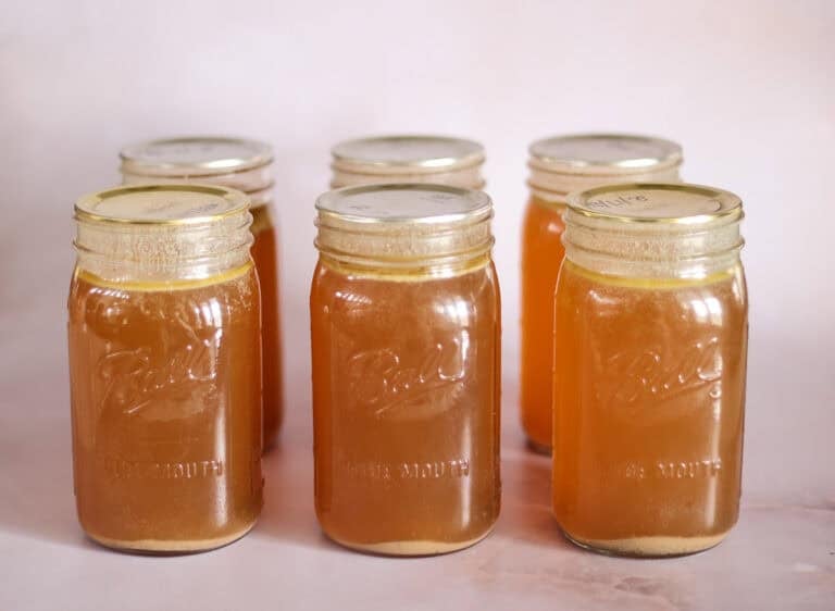 six jars of pressure canned bone broth with rings removed.