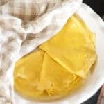 egg wraps folded and stacked in pie plate covered with tea towel.