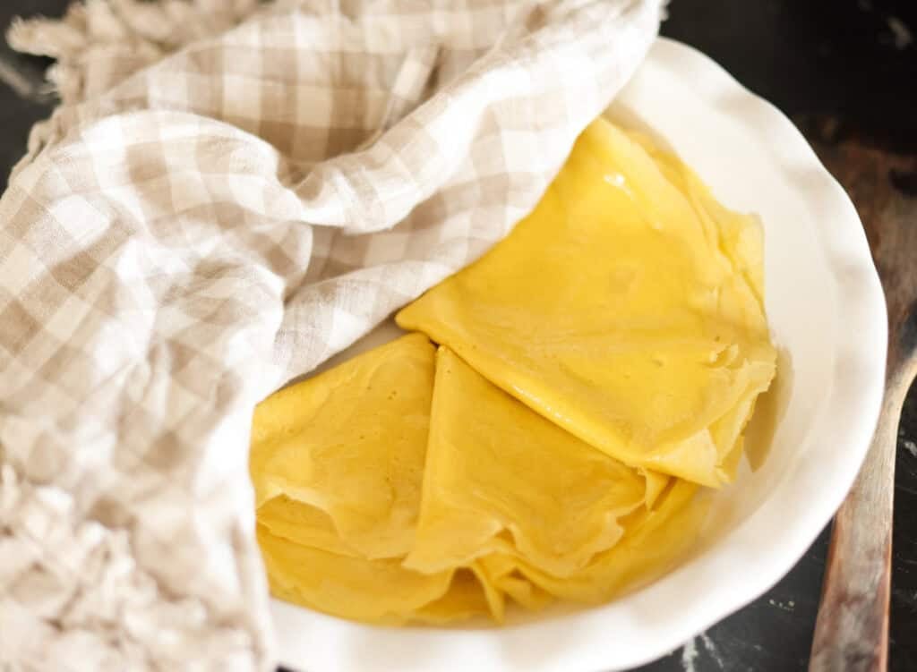 high protein egg wraps folded and stacked in pie plate.