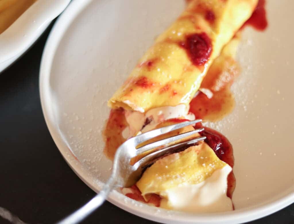 egg wrap filled with cream filling topped with strawberry glaze.