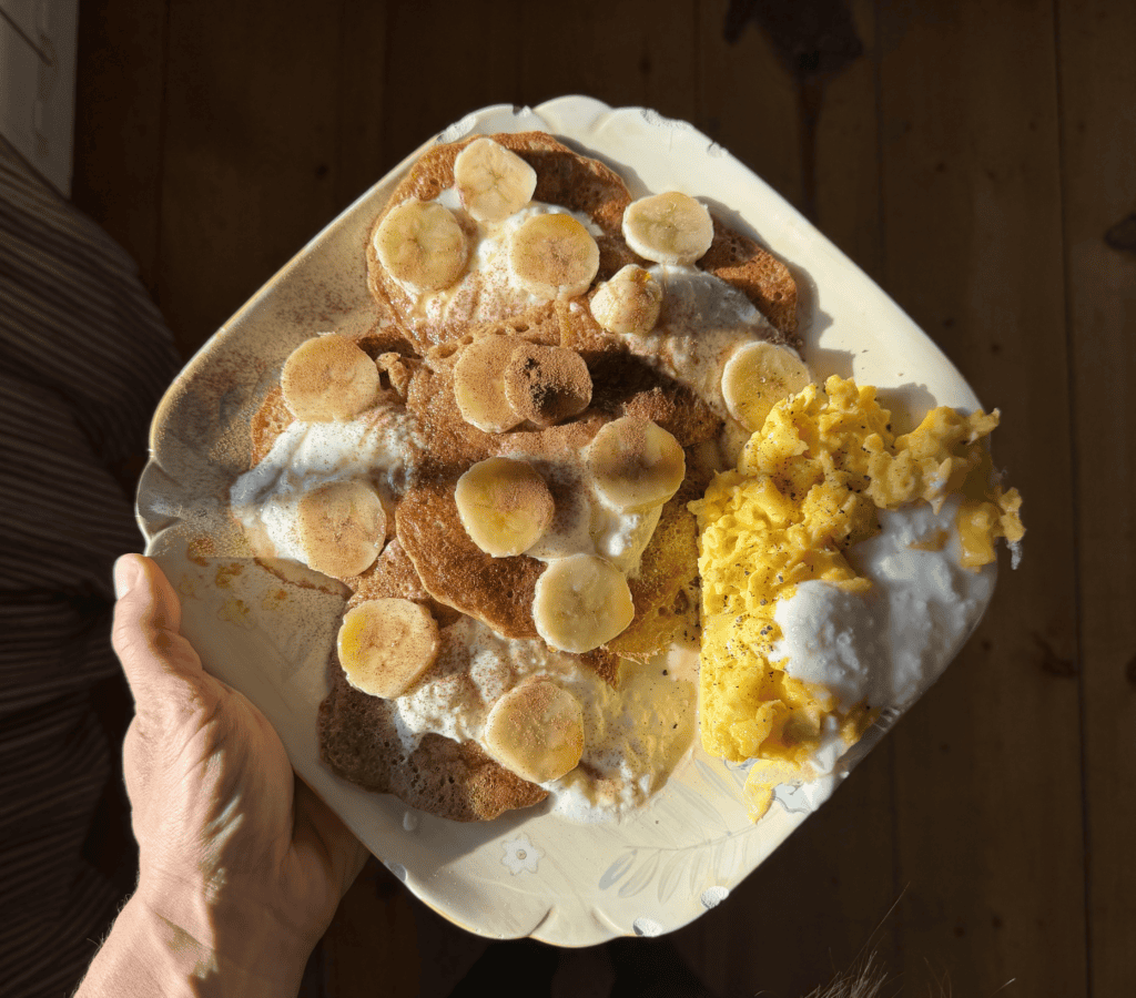 high protein sourdough pancakes topped with yogurt banana maple syrup and cinnamon.