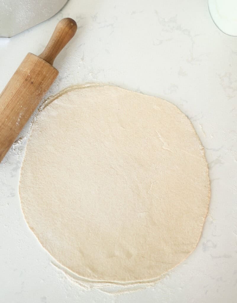 rolled out pizza dough on floured surface.