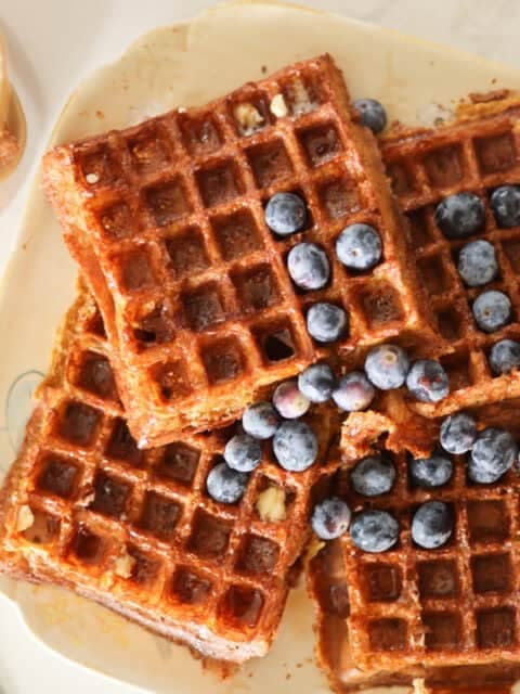 plate of sourdough belgian waffles with fresh blueberries.